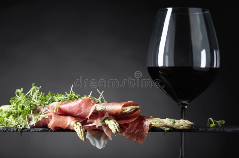 Espárrago envuelto en prosciutto con el vino rojo fotografía de archivo libre de regalías Espárrago envuelto en prosciutto con el vino rojo fotografía de archivo libre de regalías
