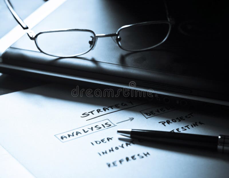 Business strategy plan workflow diagram written on a paper with computer in the background. Conceptual scheme for business planning. Business strategy plan workflow diagram written on a paper with computer in the background. Conceptual scheme for business planning.