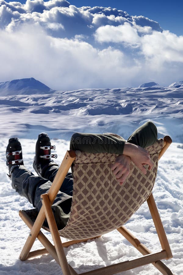 Esquiador nas montanhas do inverno que descansam no sol-vadio