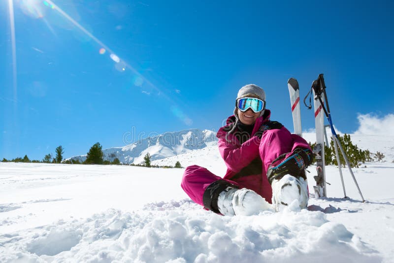 Esquiador que descansa sobre la cuesta del esquí