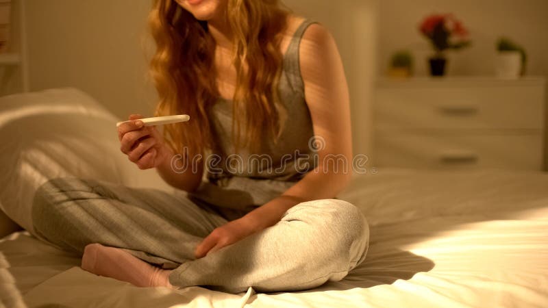 Essai de grossesse de participation de jeune femme et regarder le résultat acceptable, contrôle image libre de droits Essai de grossesse de participation de jeune femme et regarder le résultat acceptable, contrôle image libre de droits