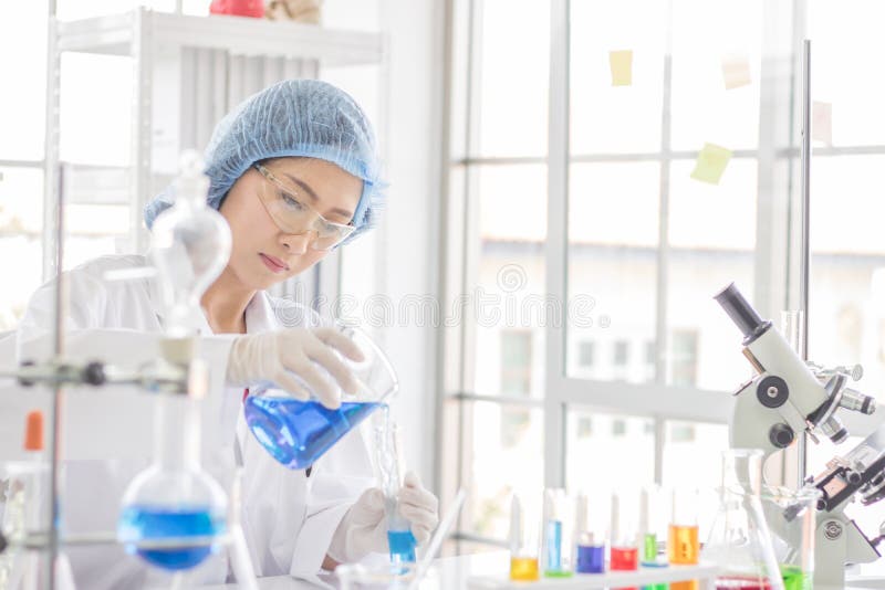 Essai femelle de scientifique au sujet de produit chimique dans le laboratoire image stock Essai femelle de scientifique au sujet de produit chimique dans le laboratoire image stock