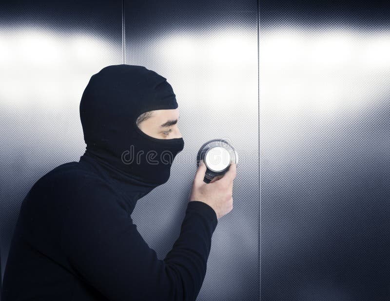 Essais de voleur pour ouvrir un coffre-fort photo stock Essais de voleur pour ouvrir un coffre-fort photo stock