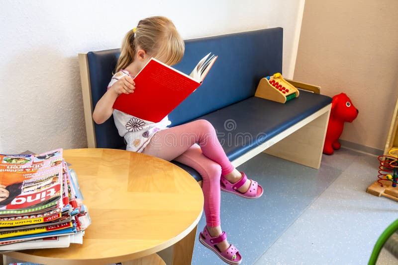 Essen, Germania - 11 giugno 2018: Attesa paziente della bambina ai dottori sala di attesa immagine stock libera da diritti Essen, Germania - 11 giugno 2018: Attesa paziente della bambina ai dottori sala di attesa immagine stock libera da diritti