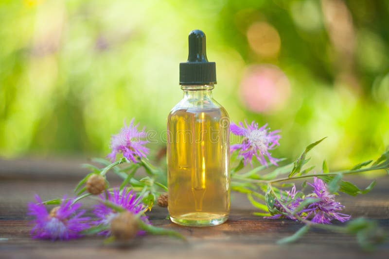 Essence of Lavender Flowers on Table in Beautiful Glass Bottle Stock
