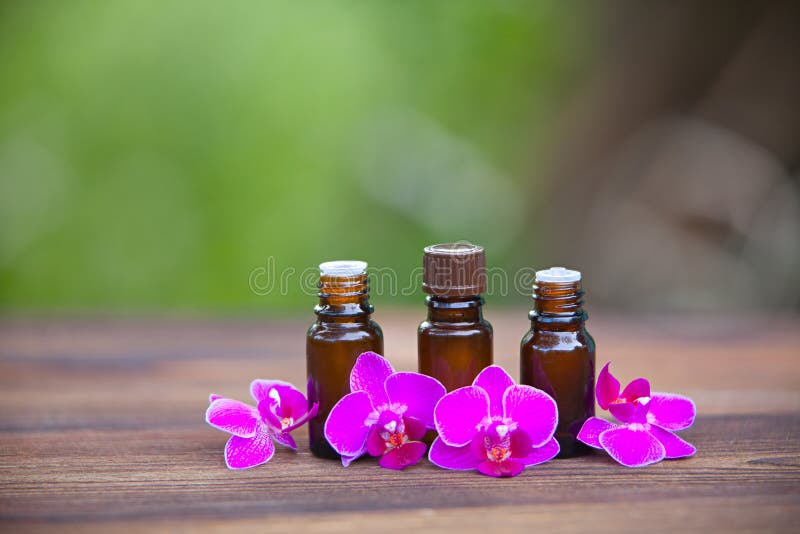 Essence of Orchid Flowers on Table in Beautiful Glass Jar Stock Photo
