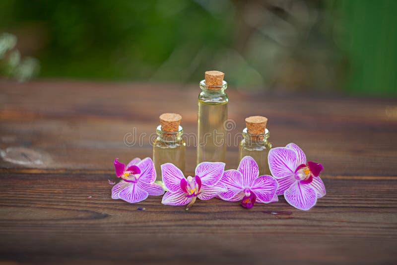 Essence of Orchid Flowers on Table in Beautiful Glass Jar Stock Photo