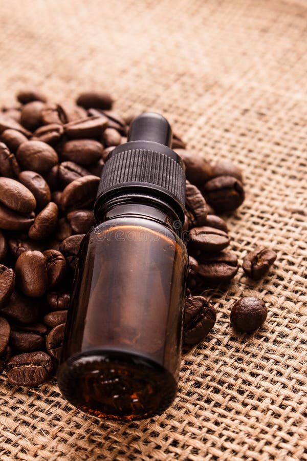 Essential Oil of Coffee Beans on a Wooden Background Stock Photo
