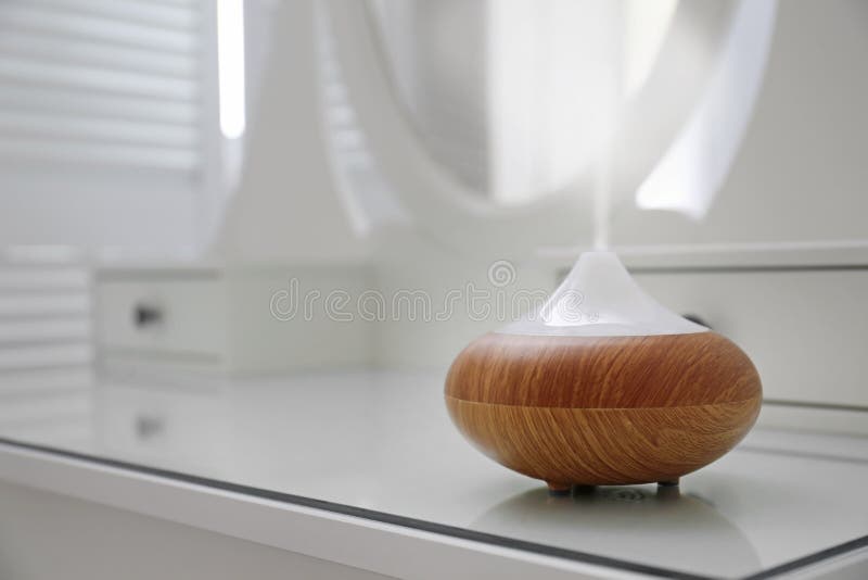 Essential oils diffuser on white table. Space for text royalty free stock photo