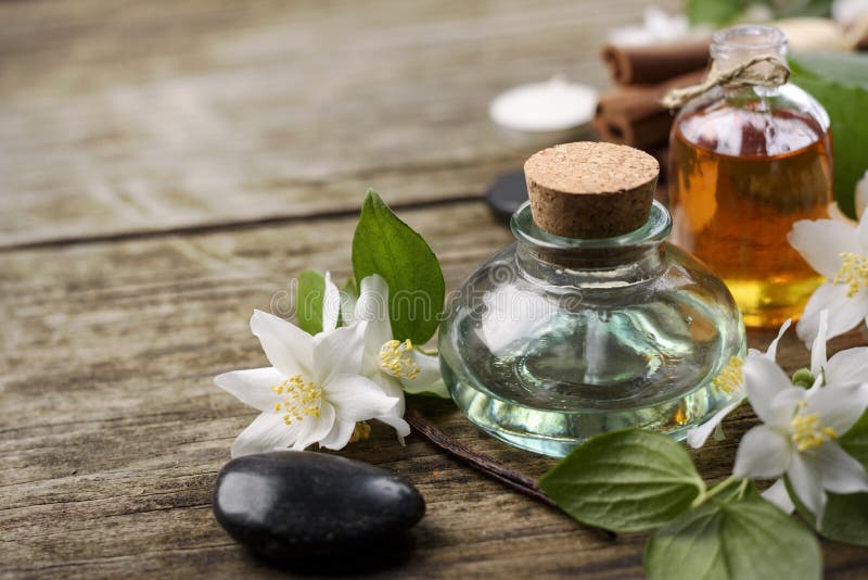 Essential oils with jasmine, cinnamon and vanilla on rustic wooden table,. Essential oils with jasmine, cinnamon and vanilla on rustic wooden table,