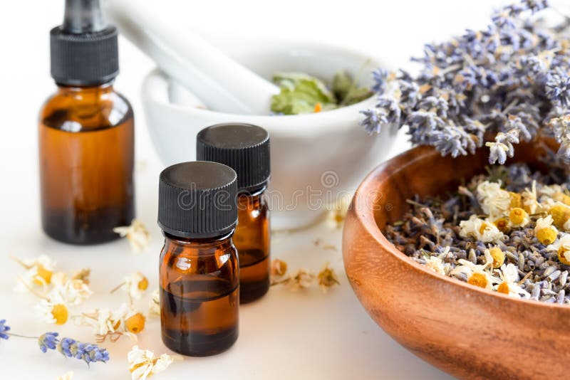 Alternative medicine with essential oils and herbs in white background. Alternative medicine with essential oils and herbs in white background