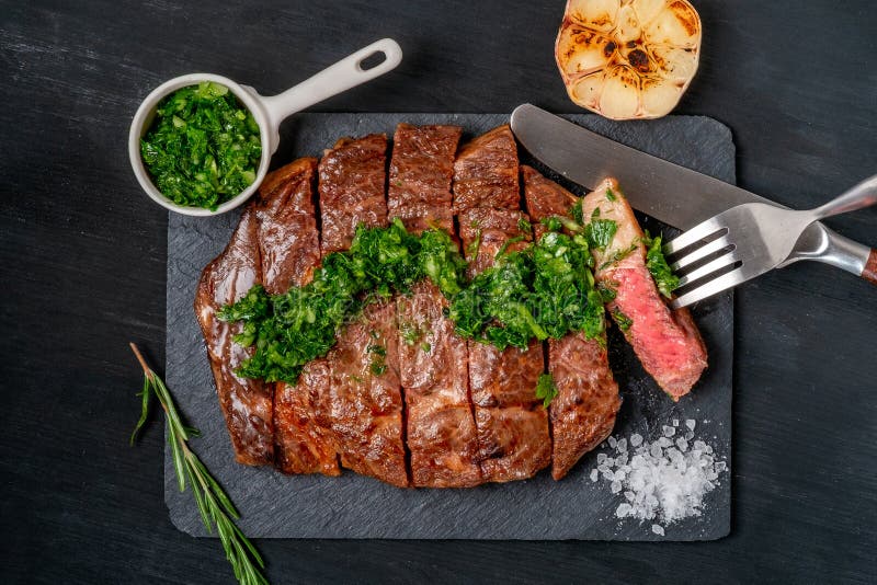 Essfertiges Schwarzes Angus-Rindfleischrippen-Augensteak Filets mit Kräutern Knoblauch und Soße auf Schieferbrett lizenzfreies stockfoto