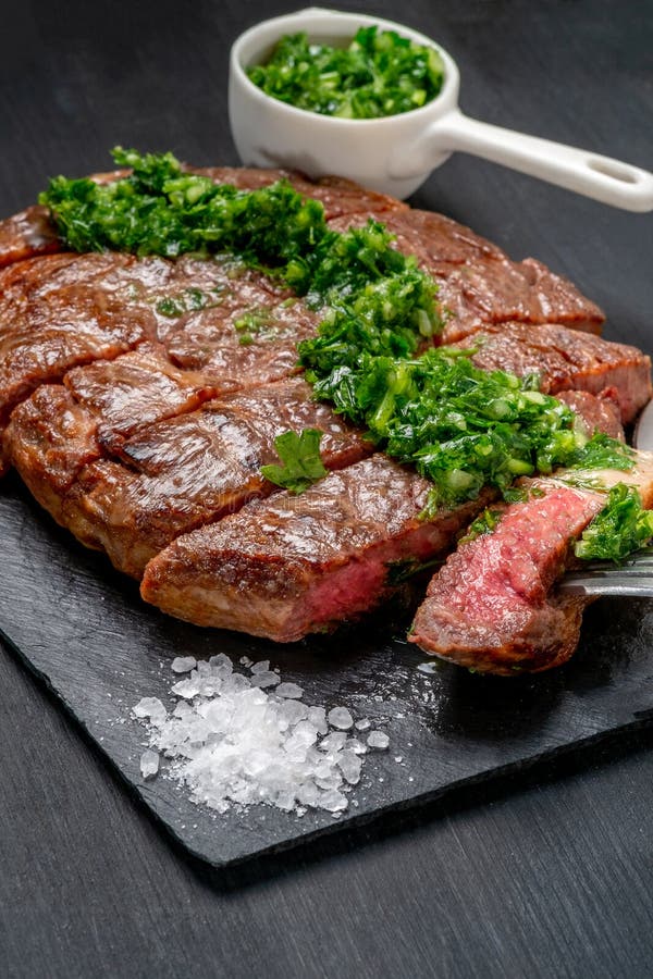 Essfertiges Schwarzes Angus-Rindfleischrippen-Augensteak Filets mit Kräutern Knoblauch und Soße auf Schieferbrett stockfoto