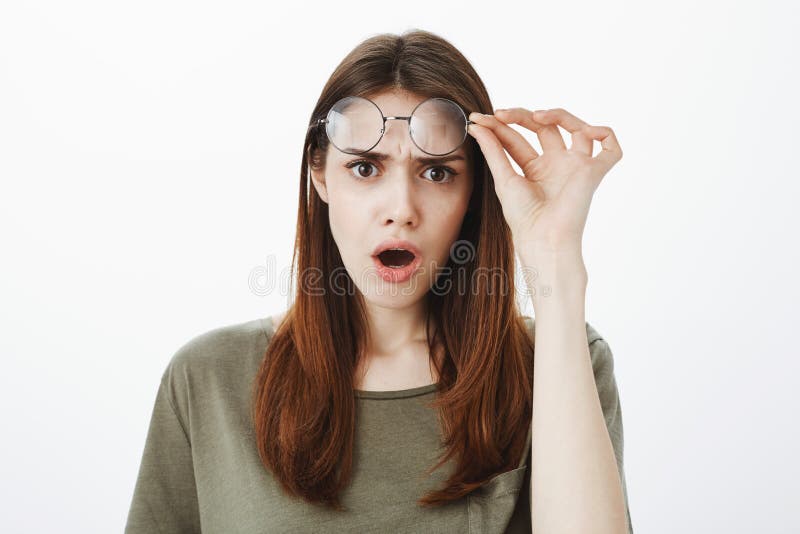 Est diable ce Portrait de femme européenne frustrante outragée avec les cheveux bruns, enlevant des verres, fronçant les sourcils image stock Est diable ce Portrait de femme européenne frustrante outragée avec les cheveux bruns, enlevant des verres, fronçant les sourcils image stock
