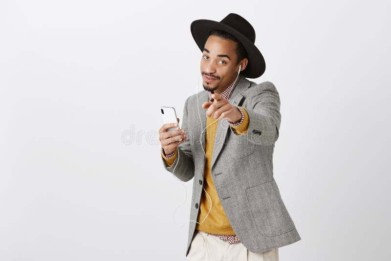 Esta canción está sobre usted Retrato del estudiante elegante de piel morena encantador en el sombrero y el equipo de moda que so foto de archivo libre de regalías Esta canción está sobre usted Retrato del estudiante elegante de piel morena encantador en el sombrero y el equipo de moda que so foto de archivo libre de regalías