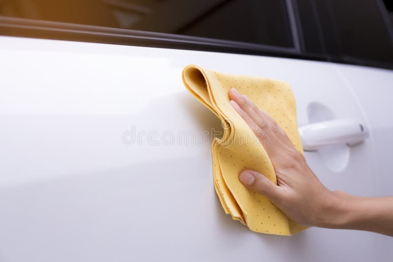 Esta imagem é uma imagem de limpar o carro com um pano amarelo do microfiber pelas mãos imagem de stock royalty free Esta imagem é uma imagem de limpar o carro com um pano amarelo do microfiber pelas mãos imagem de stock royalty free