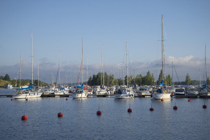 Estacionamento de embarcações pequenas do tamanho no porto do lago Saimaa em uma manhã do verão Lappeenranta imagens de stock royalty free Estacionamento de embarcações pequenas do tamanho no porto do lago Saimaa em uma manhã do verão Lappeenranta imagens de stock royalty free