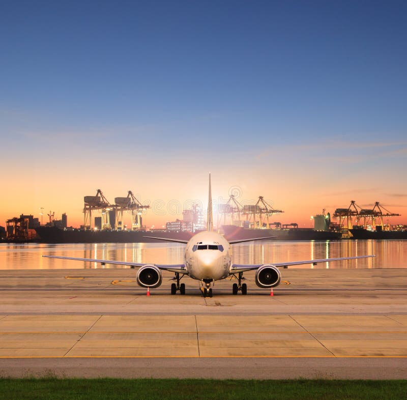 Estacionamiento del avión de carga en pistas del aeropuerto y puerto de envío detrás fotografía de archivo Estacionamiento del avión de carga en pistas del aeropuerto y puerto de envío detrás fotografía de archivo