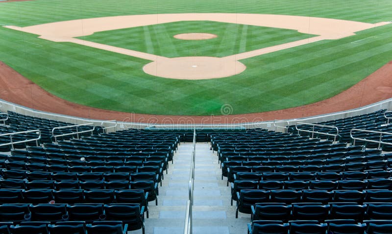 Baseball stadium with seating and a baseball diamond with green grass. Baseball stadium with seating and a baseball diamond with green grass