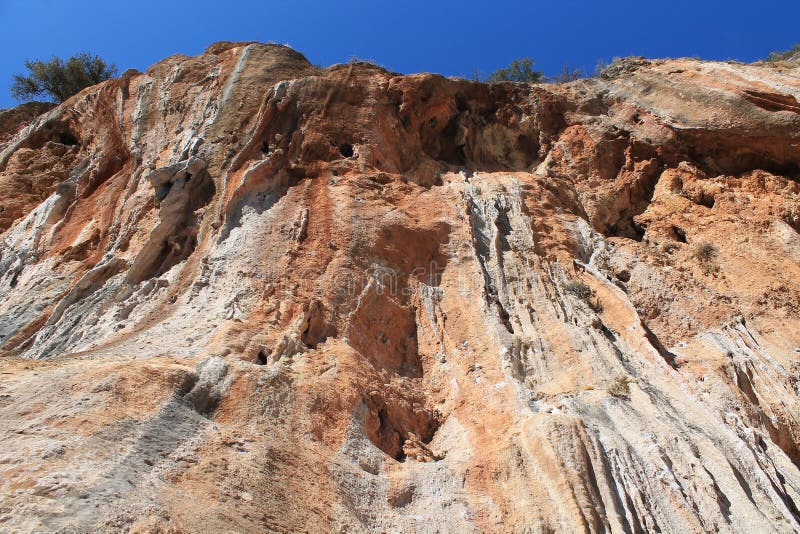 Rock climbing wall. Wind-eroded rock formations with colonets of red and yellow stone. Picturesque valley area for climbing. Rock climbing wall. Wind-eroded rock formations with colonets of red and yellow stone. Picturesque valley area for climbing