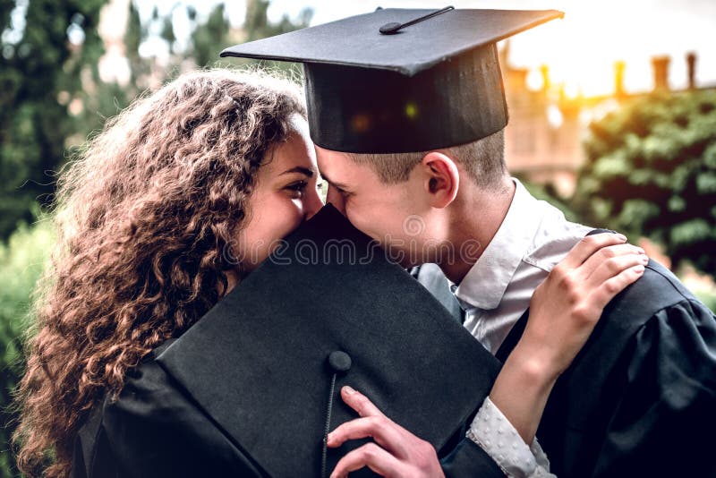 Estamos entrando juntos en edad adulta Un par cariñoso de graduados se está besando foto de archivo Estamos entrando juntos en edad adulta Un par cariñoso de graduados se está besando foto de archivo
