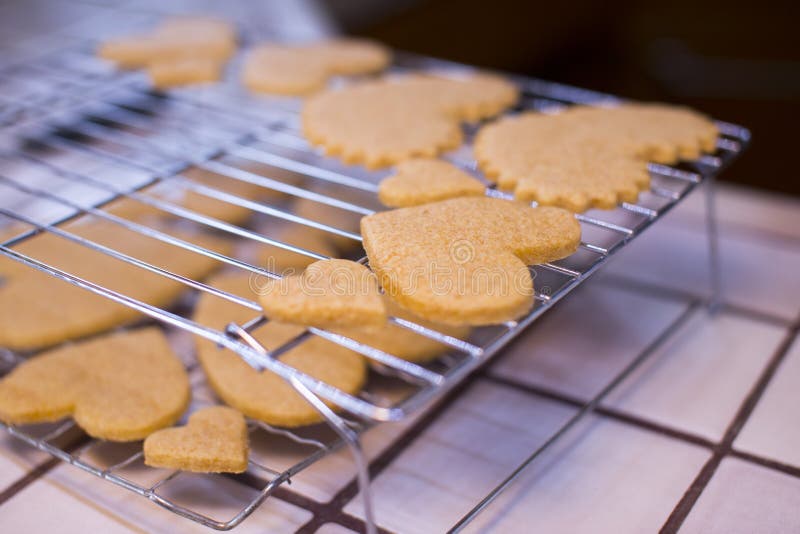 Estantes de enfriamiento galletas en forma de corazón del día de tarjeta del día de San Valentín de las diversas fotografía de archivo Estantes de enfriamiento galletas en forma de corazón del día de tarjeta del día de San Valentín de las diversas fotografía de archivo