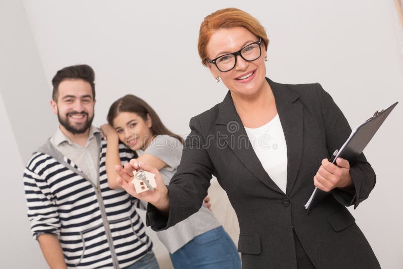 Estate agent is ready to hand over the keys of an apartment to new owners after signing the agreement.