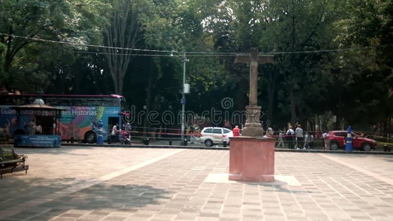 Estatua de cruz de piedra en un parque tranquilo de la ciudad de coyoacan méxico