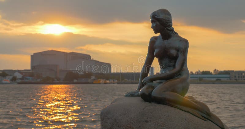 Estatua de la sirena en la piedra en el mar en la puesta del sol imagenes de archivo Estatua de la sirena en la piedra en el mar en la puesta del sol imagenes de archivo