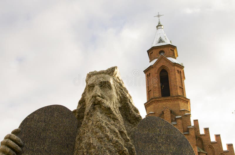 Estatua de Moses y un campanario de una iglesia gótica en un fondo fotos de archivo Estatua de Moses y un campanario de una iglesia gótica en un fondo fotos de archivo