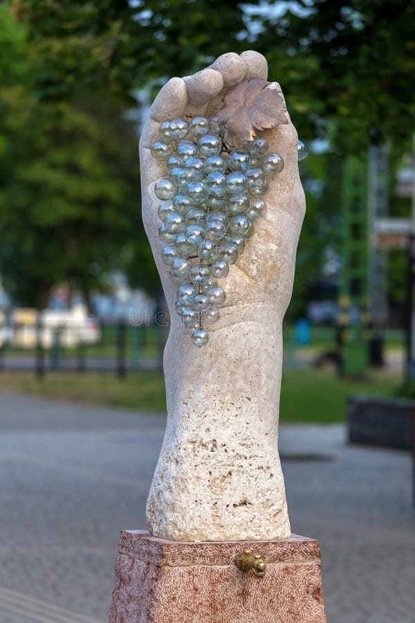 Estatua hermosa que representa la mano y la uva en el pueblo húngaro Badacsony fotografía de archivo libre de regalías Estatua hermosa que representa la mano y la uva en el pueblo húngaro Badacsony fotografía de archivo libre de regalías