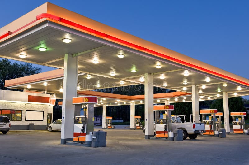 Early evening time exposure of modern retail gasoline station. All identifying logos and trademarks have been removed, and stationâ€™s original color scheme has been replaced. Early evening time exposure of modern retail gasoline station. All identifying logos and trademarks have been removed, and stationâ€™s original color scheme has been replaced.