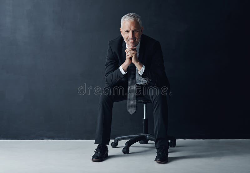 Este un exemplu de succes profesional. portretul studioului unui om de afaceri matur pe fond întunecat. stock photography