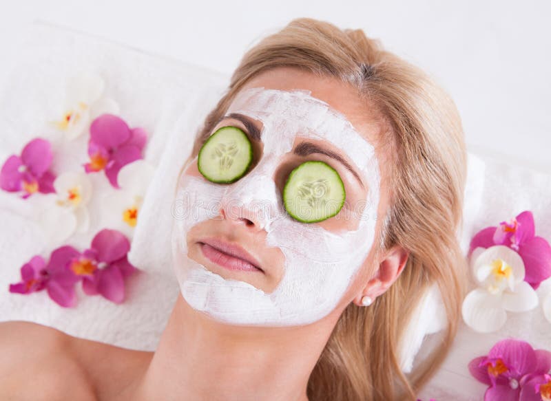 Esteticista que aplica a máscara facial na cara da mulher imagem de stock royalty free Esteticista que aplica a máscara facial na cara da mulher imagem de stock royalty free