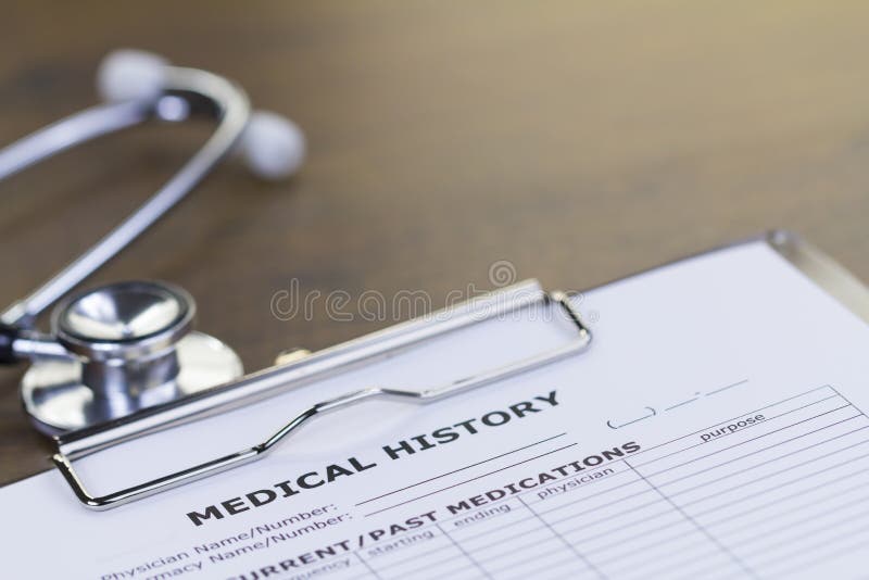 Stethoscope and Medical History Report on Brown Wooden Desktop with Upper Space. Stethoscope and Medical History Report on Brown Wooden Desktop with Upper Space