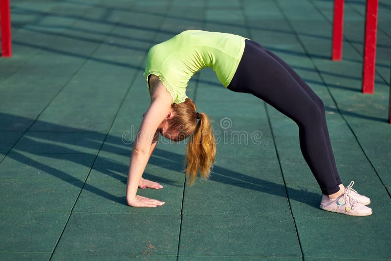 Esticando o treinamento da mulher do danser ou da ginasta treina na terra de esportes do exercício Fazendo a ponte do exercício fotografia de stock royalty free Esticando o treinamento da mulher do danser ou da ginasta treina na terra de esportes do exercício Fazendo a ponte do exercício fotografia de stock royalty free