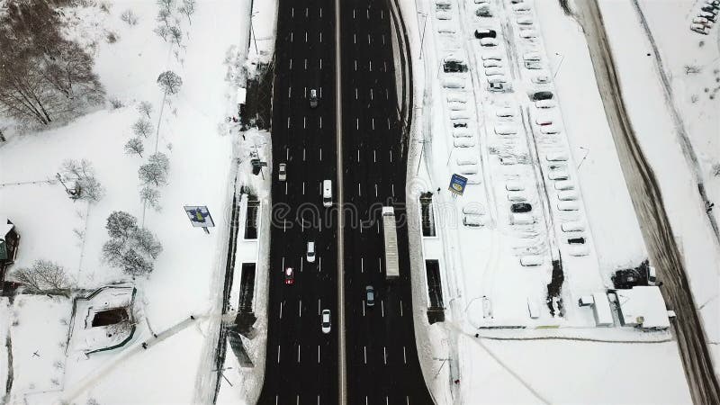 Estrada coberto de neve da vista aérea com os carros no inverno
