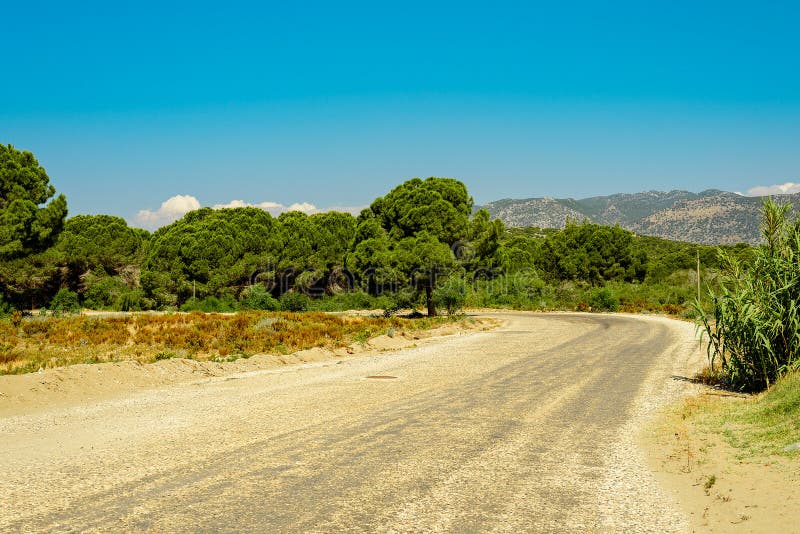 A estrada do cascalho do país vai à floresta e às montanhas, minimalismo, ninguém, fundo limpo fotografia de stock A estrada do cascalho do país vai à floresta e às montanhas, minimalismo, ninguém, fundo limpo fotografia de stock