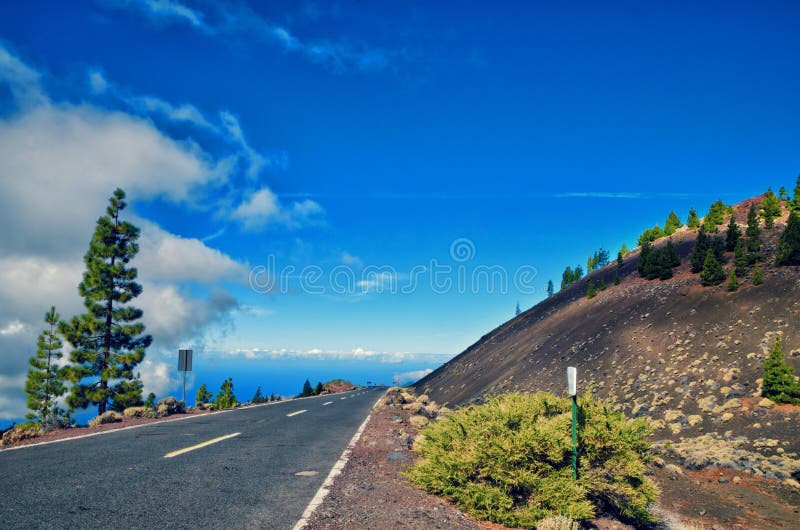 Estrada no parque nacional do EL Teide Estrada reta através das rochas da lava Tenerife, Ilhas Canárias, Spain fotografia de stock royalty free Estrada no parque nacional do EL Teide Estrada reta através das rochas da lava Tenerife, Ilhas Canárias, Spain fotografia de stock royalty free