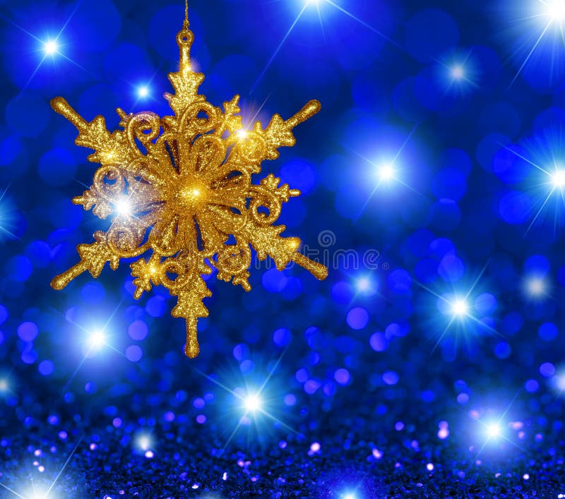Estrela do floco de neve do ouro no fundo das estrelas azuis imagem de stock Estrela do floco de neve do ouro no fundo das estrelas azuis imagem de stock