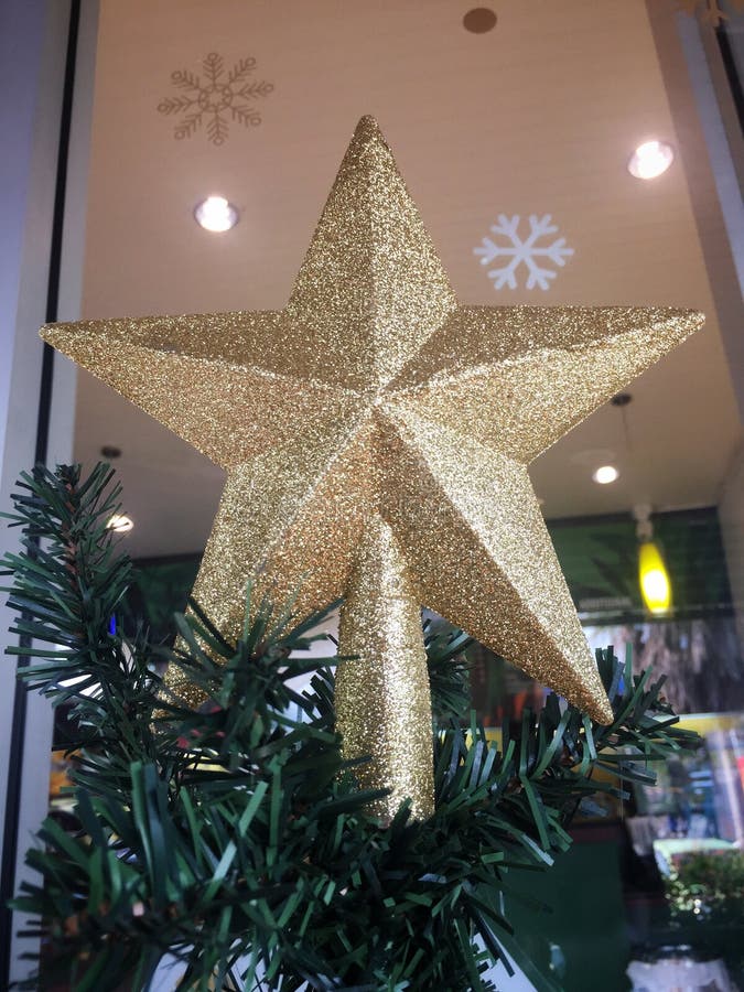 Decoração Clássica De árvore De Natal. Estrelas Douradas Na Parede Do  Quarto Ensolarado Brilhante Imagem de Stock - Imagem de parede, estrelas:  253139809