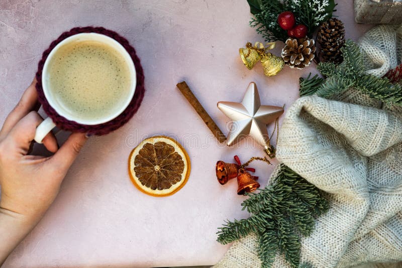 Estrelas douradas, caixa de presente, mãos com xícara de café, ramo de árvore do Natal e decorações em claro - fundo textured cor imagem de stock Estrelas douradas, caixa de presente, mãos com xícara de café, ramo de árvore do Natal e decorações em claro - fundo textured cor imagem de stock