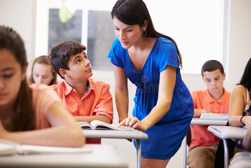 Estudante In Classroom da escola de Helping Male High do professor imagens de stock Estudante In Classroom da escola de Helping Male High do professor imagens de stock