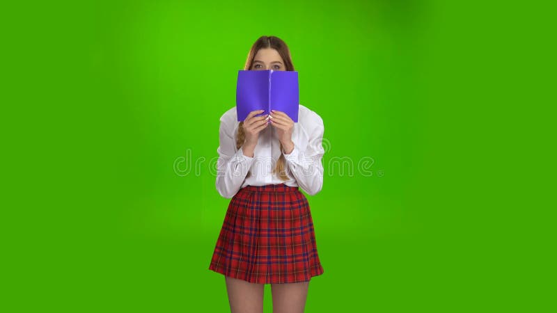 A estudante cobriu sua cara com um caderno violeta Tela verde