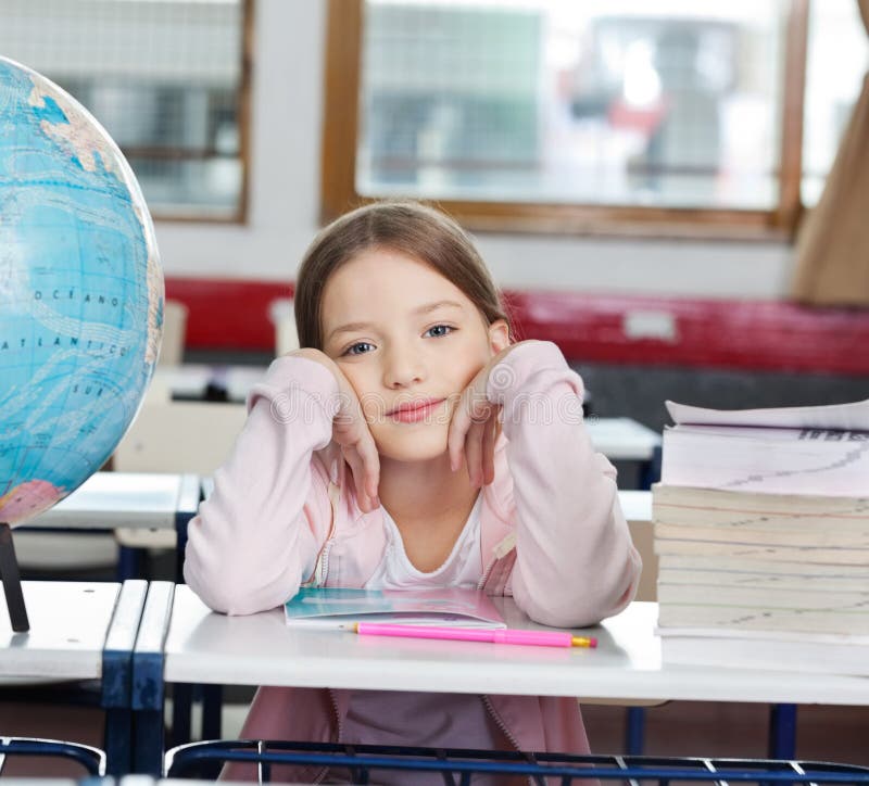 Estudante com a pilha de livros e de globo na mesa imagens de stock Estudante com a pilha de livros e de globo na mesa imagens de stock