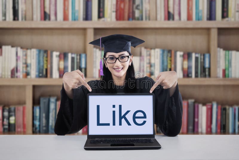 Estudante da graduação na biblioteca imagem de stock Estudante da graduação na biblioteca imagem de stock