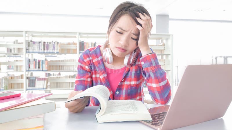 Estudante de mulher na biblioteca imagens de stock Estudante de mulher na biblioteca imagens de stock