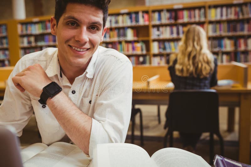 Estudante de sorriso que usa seu portátil ao trabalhar fotos de stock Estudante de sorriso que usa seu portátil ao trabalhar fotos de stock