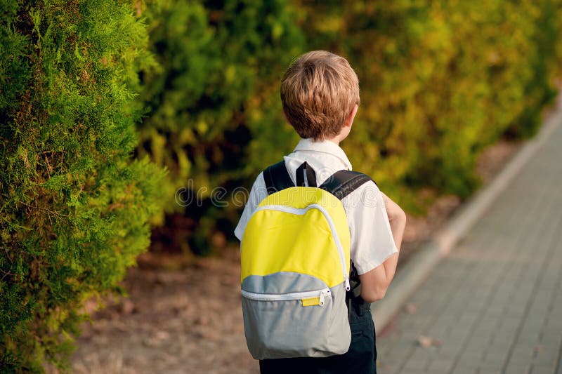 Estudante elementar Pouco 7 anos de menino idoso com a trouxa que vai à escola foto de stock Estudante elementar Pouco 7 anos de menino idoso com a trouxa que vai à escola foto de stock