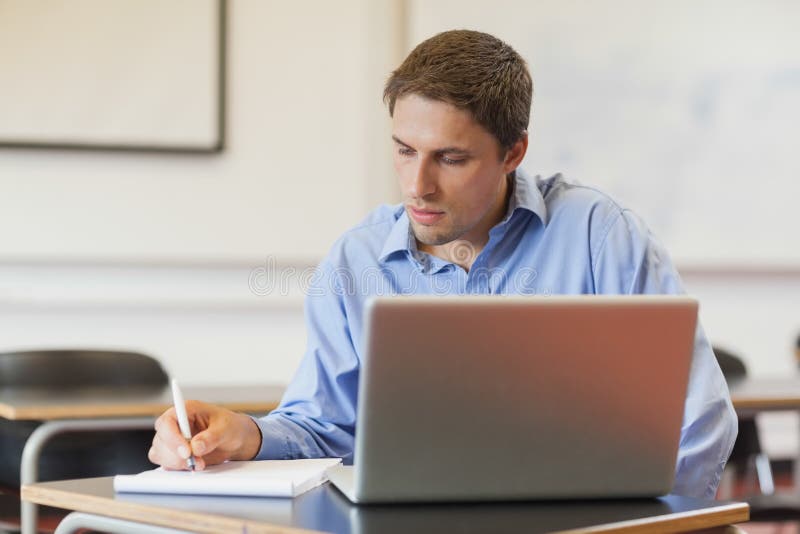Estudante maduro masculino concentrado que usa seu caderno para aprender